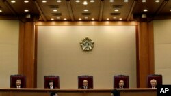 Park Han-chul, center, president of South Korea's Constitutional Court, sits with other judges before the judgment at the Constitutional Court in Seoul, South Korea, Thursday, Feb. 26, 2015.