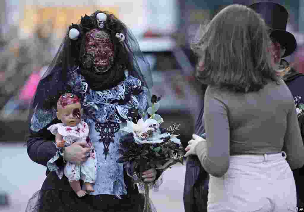 People dressed up in scary costumes arrive at the city center for the annual Zombie Walk and Halloween Parade in Essen, Germany, Oct. 31, 2021.