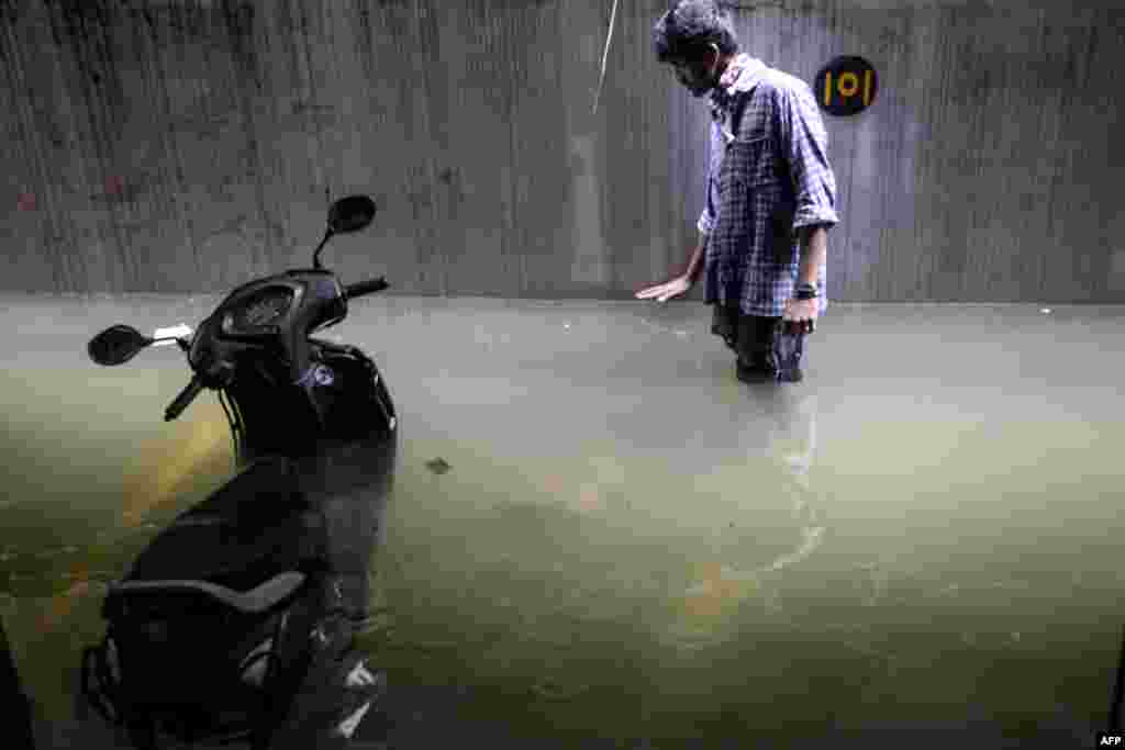 A resident shows the level of water in his cellar area at an apartment following heavy rains in Hyderabad, India.
