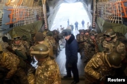 Kyrgyz service members board a military aircraft heading to Kazakhstan amid mass protests in the country, as part of a peacekeeping mission of the Collective Security Treaty Organisation, at Kant military air base, Kyrgyzstan, Jan. 7, 2022.