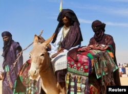 Tuaregs ride on camels during a festival in Iferouane, Niger, Feb. 17, 2018.