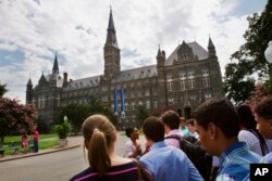 FILE - Prospective students tour Georgetown University's campus in Washington, July 10, 2013.