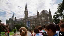 FILE - Prospective students tour Georgetown University's campus in Washington, July 10, 2013. 