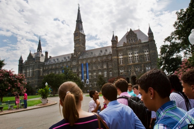 FILE - Prospective students tour Georgetown University's campus in Washington, July 10, 2013.