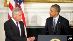 Le président Barack Obama (à dr.), saluant Chuck Hagel aprés avoir annoncé sa démission (AP)