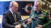 El presidente ruso, Vladimir Putin (izq), y el ministro de Defensa ruso, Sergei Shoigu, visitan una exhibición militar después de asistir a una reunión de la Junta del Ministerio de Defensa de Rusia en el Centro de Control de Defensa Nacional en Moscú, el 21 de diciembre de 2021.