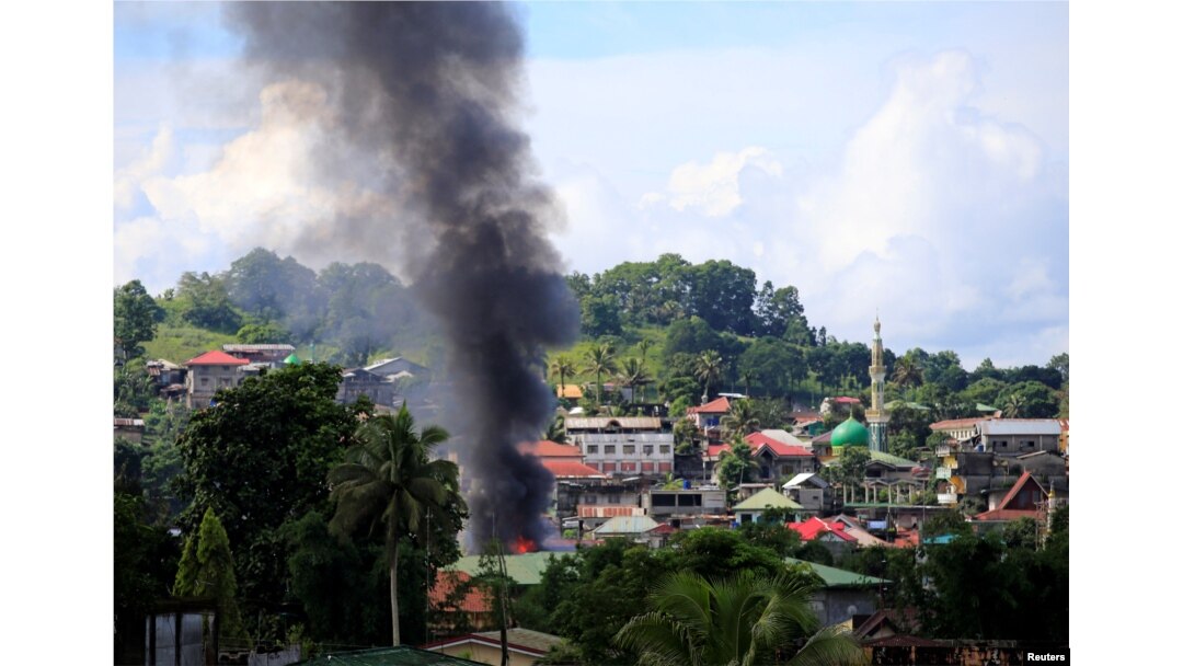 Smoke billowing from a burning building is seen as government troops continue their assault on insurgents from the Maute group, who have taken over large parts of Marawi City, Philippines, June 1, 2017.
