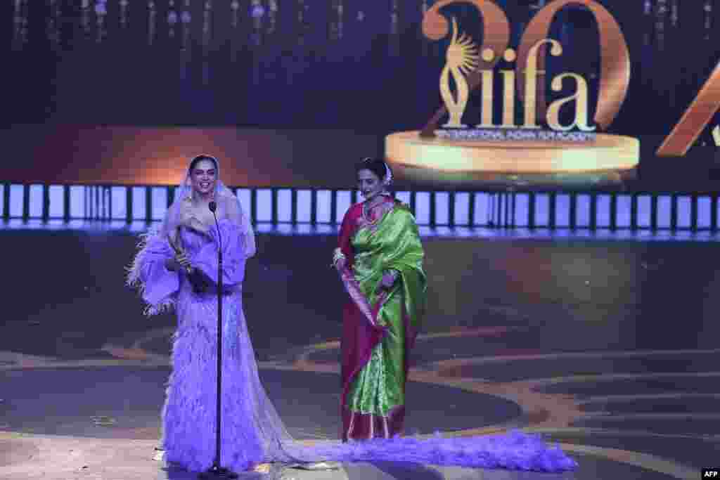 Bollywood actor Deepika Padukone (left) reacts after receiving the Best Actress in Last 20 Years award from actor Rekha (right) during the 20th International Indian Film Academy (IIFA) Awards at NSCI Dome in Mumbai.