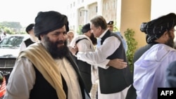 طالبان وفد کے 2019 میں دورۂ پاکستان کے دوران وزیرِ خارجہ شاہ محمود قریشی استقبال کر رہے ہیں۔ (فائل فوٹو)