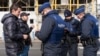 Des policiers vérifient l'identité de deux hommes qui ont tenté de traverser la frontière franco-belge à Adinkerke, en Belgique, le 24 février 2016.