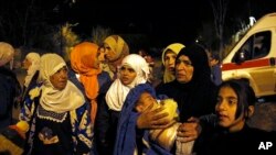 FILE - People wait to leave the besieged town of Madaya, northwest of Damascus, Syria, on Jan. 11, 2016.