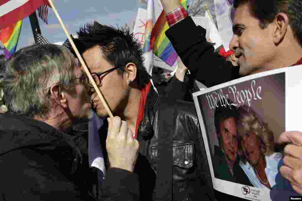 27일 미국 연방대법원 앞에서 동성혼 금지법에 항의하는 시위대 행렬 가운데, 약혼한 동성 커플이 입맞추고 있다.
