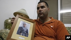 Palestinian Mohammed Tamimi holds a picture of his sister Ahlam Tamimi, held in an Israeli jail, during an interview in the West Bank city of Ramallah, October 16, 2011.
