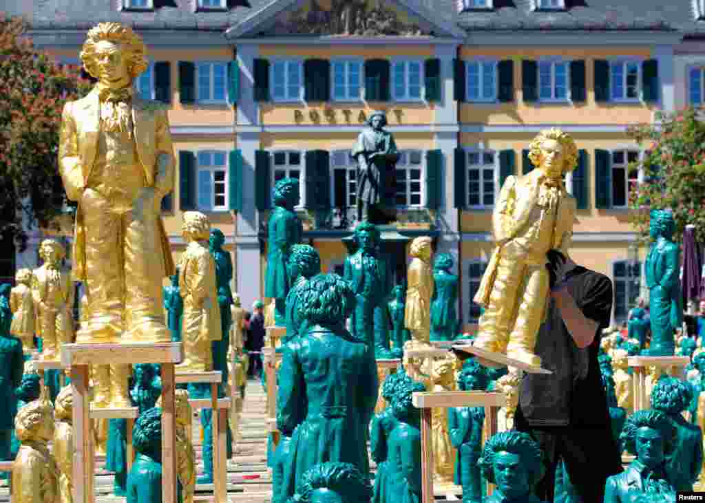 A worker sets up one of hundreds of Ludwig van Beethoven plastic sculptures designed by German conceptual artist Ottmar Hoerl to mark the 250th birth anniversary of the German composer, in Bonn.