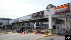 FILE - Vehicles pay a toll at the Detroit-Windsor tunnel in Detroit, Michigan, on the U.S.-Canada border, Aug. 9, 2021. 