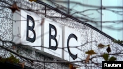 FILE - A BBC logo is seen at the company's main offices, in west London. Three journalists for British Broadcasting Corporation were attacked in Malawi under suspicion of being vampires.