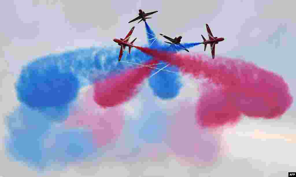 Tim Aerobatik Angkatan Udara Inggris, the Red Arrows, memamerkan kebolehan di udara sebelum acara balap mobil Grand Prix Formula Satu di sirkuit Silverstone, Inggris.