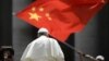 当教宗方济各在梵蒂冈圣彼得广场结束对信众的每周讲话离开时，一人向他展示中国国旗。（2019年6月12日）