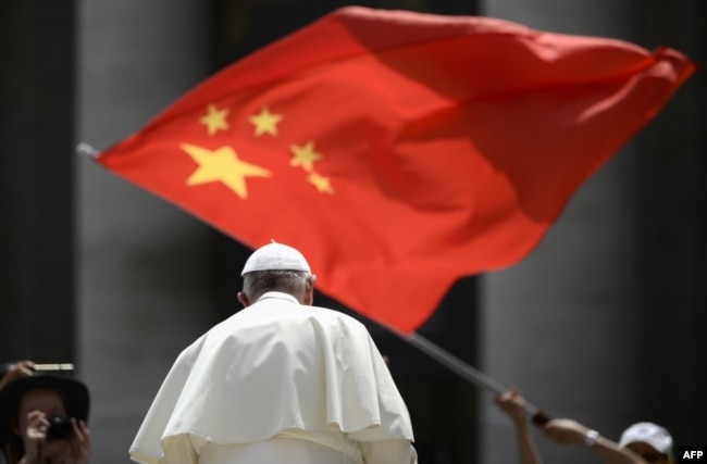 当教宗方济各在梵蒂冈圣彼得广场结束对信众的每周讲话离开时，一人向他展示中国国旗。（2019年6月12日）
