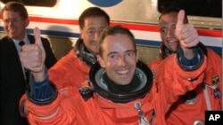 Le commandant Jean-François Clervoy, de Toulouse, en France, lève ses deux pouces face aux photographes, pendant qu’il s’avance pour monter à bord de l’"Astro-Van" avec ses collègues membres d'équipage avant le décollage de la navette spatiale Atlantis, 15 mars 1997