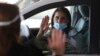 In this Friday, June 26, 2020 photo, U.S. District Judge Laurie Michelson, left, the Aath of Citizenship to Hala Baqtar during a drive-thru naturalization service in a parking structure at the U.S. Citizenship and Immigration Services headquar