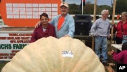 Richard and Catherine Wallace stand with a 2,261.5-pound pumpkin that Richard grew to set the North American giant pumpkin record at the Frerichs Farm Pumpkin Weigh Off in Warren, R.I.