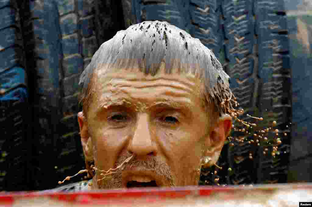 A man takes part in a &quot;Bison race&quot; competition with different kind of obstacles in a field near the town of Lahoysk, Belarus, April 29, 2018.