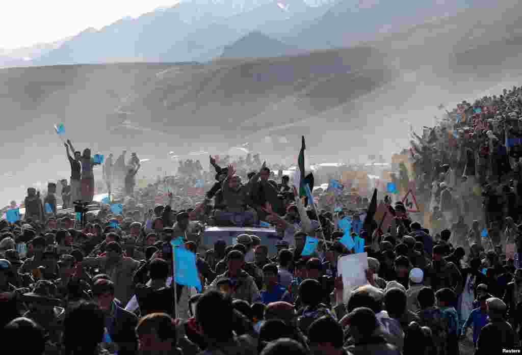 Presidential candidate Abdullah Abdullah, sitting atop a vehicle, arrives for an election campaign in Panjshir province, March 31, 2014.