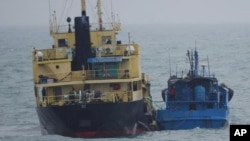 FILE - This Feb. 16, 2018, file photo released by Japan's Ministry of Defense shows what it says North Korean-flagged tanker Yu Jong 2, left, and Min Ning De You 078 lying alongside in the East China Sea performing a ship-to-ship transfer. 