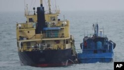日本防務省稱，2018年2月16日的這張圖片中是懸掛北韓旗的運油船Yu Jong 2號(左)和閩寧德油078號。外界擔心，這兩艘船隻傳遞的貨物可能違反了聯合國對北韓的制裁令。