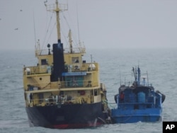 FILE - This photo released by Japan's Ministry of Defense shows what it says is the North Korean-flagged tanker Yu Jong 2, left, and the Min Ning De You 078 lying alongside in the East China Sea, Feb. 16, 2018. China said it was "highly concerned" about a reported ship-to-ship transfer on the high seas that could violate U.N. sanctions on North Korea.