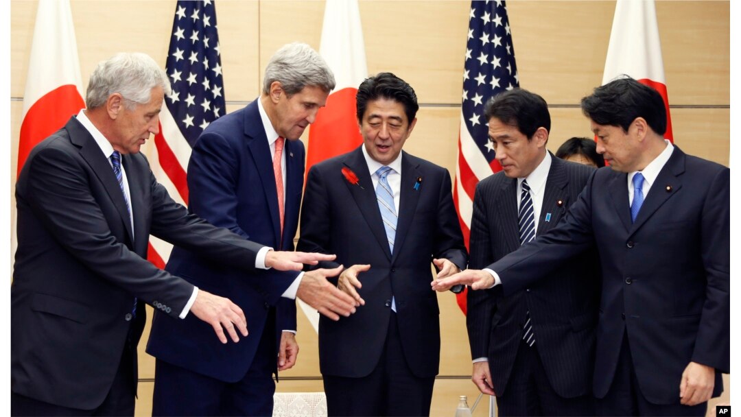 Perdana Menteri Jepang Shinzo Abe, tengah, bersiap bergandengan tangan dengan Menteri Pertahanan AS Chuck Hagel, kiri, Menteri Luar Negeri AS John Kerry, kedua dari kiri, Menteri Luar Negeri Jepang Fumio Kishida, kedua dari kanan, dan Menteri Pertahanan Jepang Itsunori Onodera sebelum pertemuan mereka di kediaman resmi perdana menteri di Tokyo, Kamis, 3 Oktober 2013. (Foto: AP)