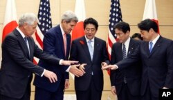 Perdana Menteri Jepang Shinzo Abe, tengah, bersiap bergandengan tangan dengan Menteri Pertahanan AS Chuck Hagel, kiri, Menteri Luar Negeri AS John Kerry, kedua dari kiri, Menteri Luar Negeri Jepang Fumio Kishida, kedua dari kanan, dan Menteri Pertahanan Jepang Itsunori Onodera sebelum pertemuan mereka di kediaman resmi perdana menteri di Tokyo, Kamis, 3 Oktober 2013. (Foto: AP)