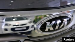 FILE - A Kia car is reflected at the showroom of the Avtomir company, a Kia cars dealership, in Moscow, Russia, March 11, 2016.