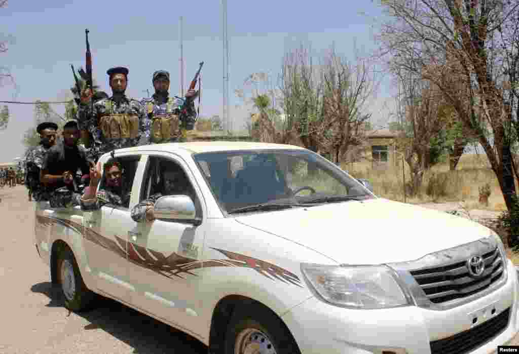 Iraqi security forces and volunteers patrol on the outskirts of the town of Udaim in Diyala province, Iraq, June 22, 2014.