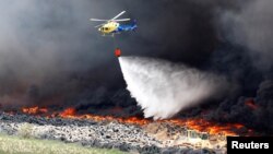 Un hélicoptère lâche de l'eau au dessus d'un incendie à Sesena, au sud de Madrid, Espagne, le 13 mai 2016.