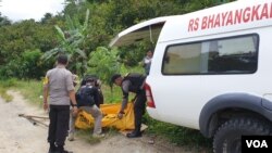 Evakuasi jenazah terduga teroris Basir alias Romzi untuk dipindahkan ke mobil ambulans Rumah Sakit Bhayangkara Polda Sulawesi Tengah, Senin (4/3) (Foto: VOA/Yoanes Litha)