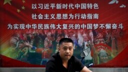 一个行人路过北京街头宣传习近平中国梦的宣传广告牌。