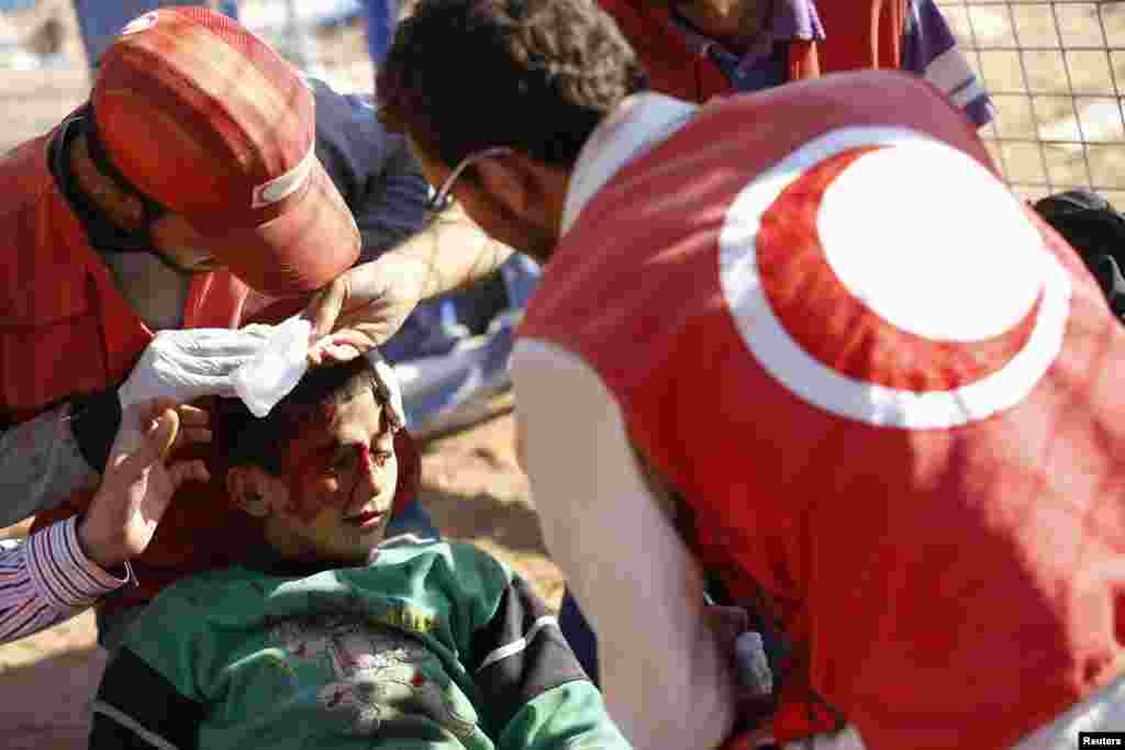 2014年9月22日土耳其医务人员在桑尼乌法省叙吕奇小镇急救在地雷爆炸中受伤的叙利亚男孩 