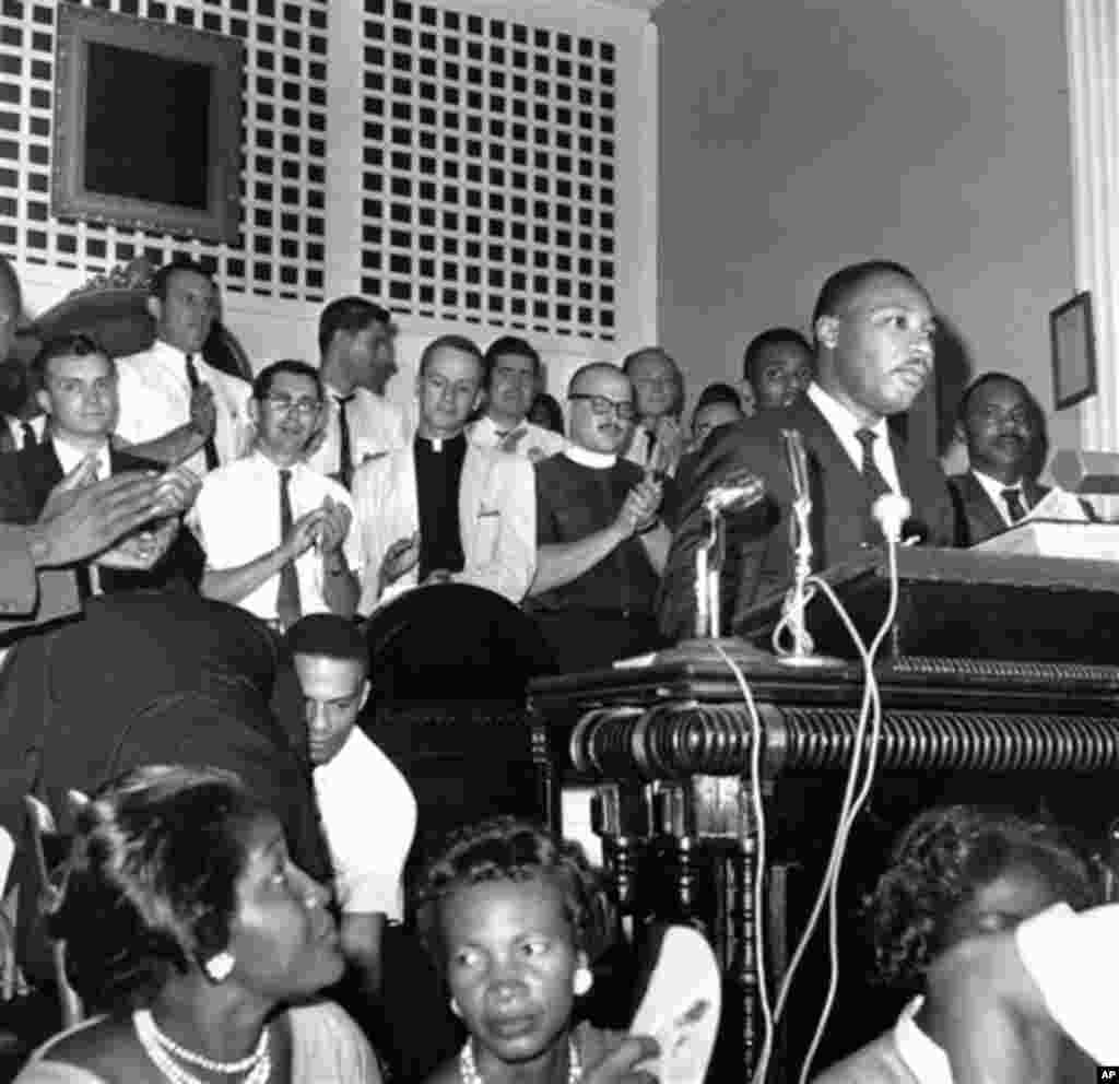 In this Aug. 28, 1962 file photo, a group of clergymen from the northern states applaud Southern Christian Leadership Conference president Martin Luther King Jr. as he speaks at a church in Albany, Ga. (AP File Photo)
