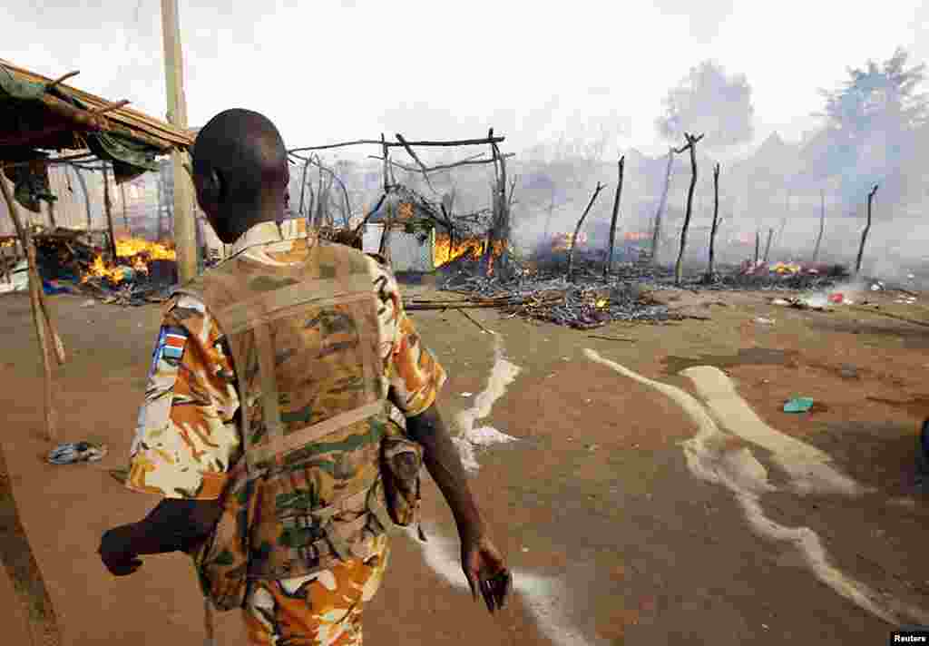 A SPLA soldier walks in a market destroyed in an air strike by the Sudanese air force in Rubkona near Bentiu, South Sudan, April 23, 2012. (Reuters)