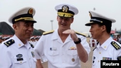 Robert L. Thomas Jr. (C), Commander of the U.S. Seventh Fleet talks with Chinese general Yuan Yubo (L) at a port in Qingdao, during the U.S. Seventh Fleet Flagship USS Blue Ridge visit to Shandong province, China, Aug. 5, 2014.