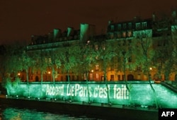 FILE - The Ile Saint-Louis is illuminated with the lettering reading 'The Paris accord is done' in Paris, Nov. 4, 2016, to celebrate the first day of the application of the Paris COP21 climate accord.