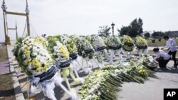 Cambodia University students lay down flowers during a memorial service near a bridge where festival goers were killed on Monday November 22, 2010, in a stampede in Phnom Penh.