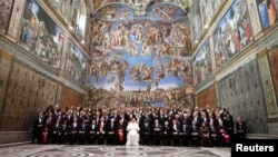 FILE - Pope Francis poses in the Sistine Chapel with members of the diplomatic corps accredited to the Holy See at the end of an audience for the traditional exchange of New Year greetings at the Vatican, Jan. 9, 2017.