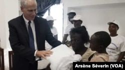 L'ambassadeur des Etats-Unis Todd Haskel remet la moustiquaire à une famille, à Kinkala, le 15 octobre (VOA/Arsène Séverin)