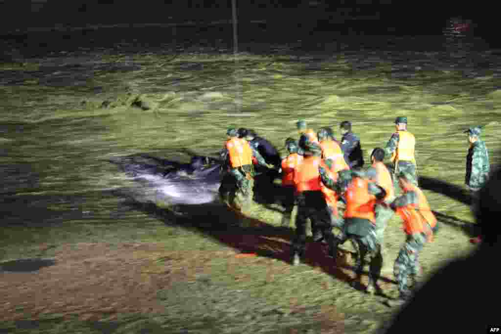 2018年7月19日，中国甘肃省临夏，武警在暴雨后从洪水中救出一名男子。甘南州合作市最大降雨量达到98毫米。