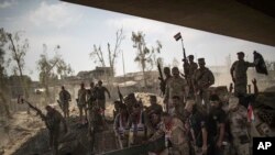 FILE - Iraqi Army soldiers gather to celebrate their gains as their fight against Islamic State militants continues in the Old City of Mosul, Iraq, July 9, 2017.