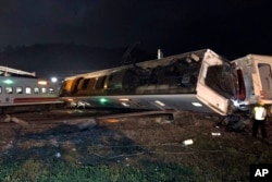 In this photo released by Taiwan Railways Administration, train carriages are scattered at the site of a train derailment in Yilan county northeastern Taiwan on Sunday, Oct. 21, 2018.