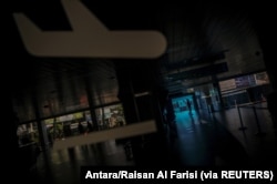 Seorang petugas keamanan penerbangan berjalan melalui pintu kedatangan domestik bandara Husein Sastranegara saat Indonesia menghentikan perjalanan laut, darat, udara, dan kereta api menjelang perayaan Idul Fitri dalam upaya mencegah penularan skala besar